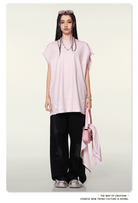 Frau in rosa Oversize-Shirt und schwarzer Hose, mit rosa Tasche und Sonnenbrille. Modetrend, Streetwear, asiatische Mode, lässiger Stil.
