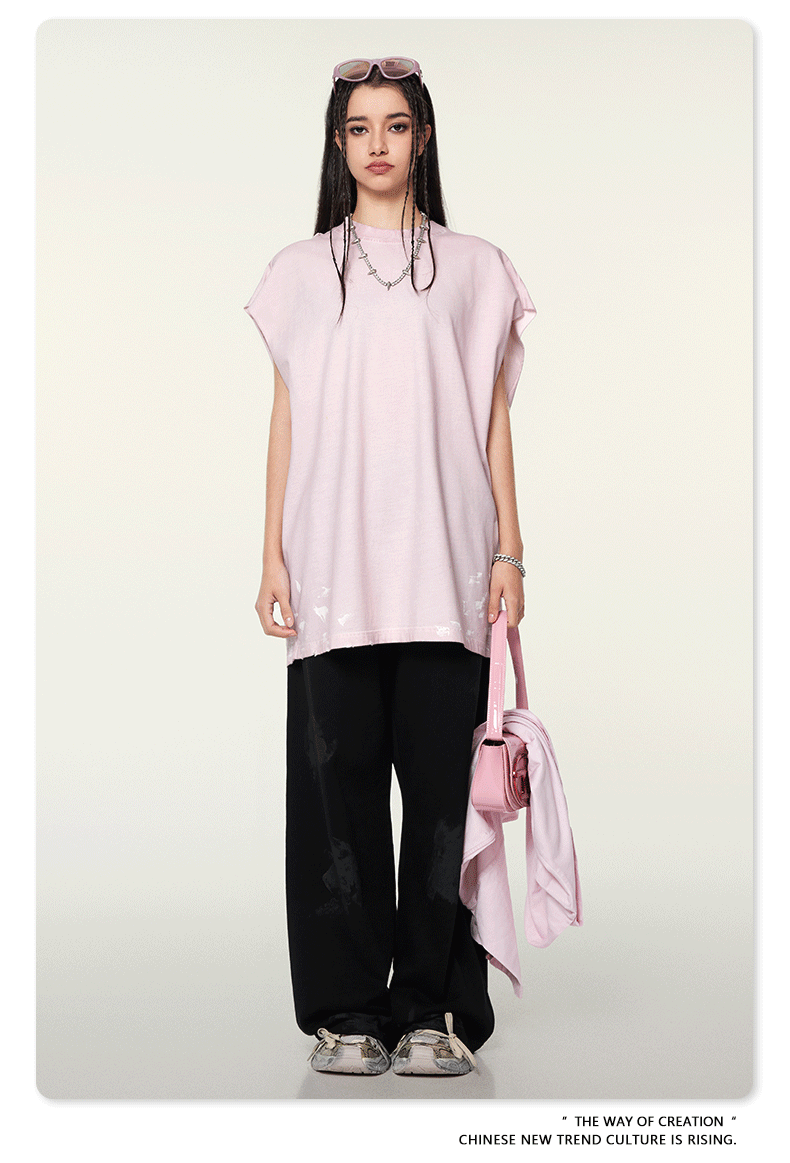 Frau in rosa Oversize-Shirt und schwarzer Hose, mit rosa Tasche und Sonnenbrille. Modetrend, Streetwear, asiatische Mode, lässiger Stil.