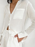 Damen Pyjama-Set aus weißem Musselin-Stoff, langärmlig mit V-Ausschnitt und Brusttasche. Bequem, atmungsaktiv, ideal für erholsamen Schlaf.