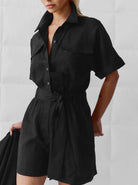 Eleganter schwarzer Jumpsuit für Damen, kurzärmelig mit Gürtel, ideal für Sommermode. Perfekt für stilvolle Freizeit- und Abendlooks.