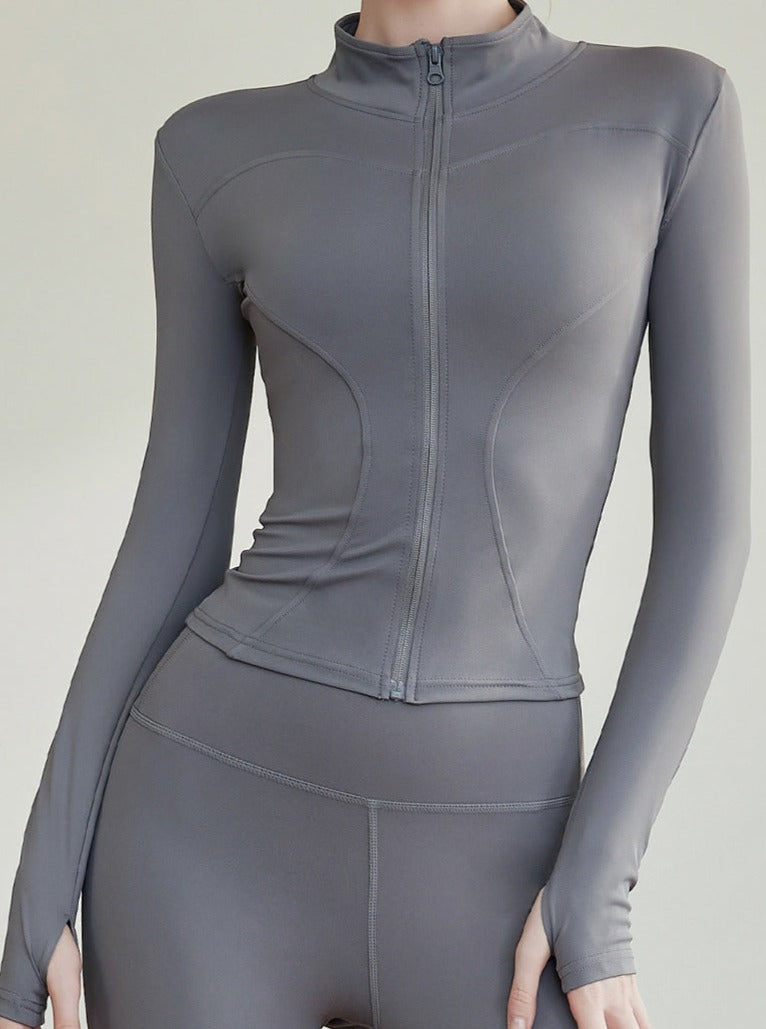 Damen-Sportjacke in Grau, figurbetont, mit Reißverschluss und langen Ärmeln. Ideal für Fitness, Yoga und Freizeit. Hochwertige Sportbekleidung.