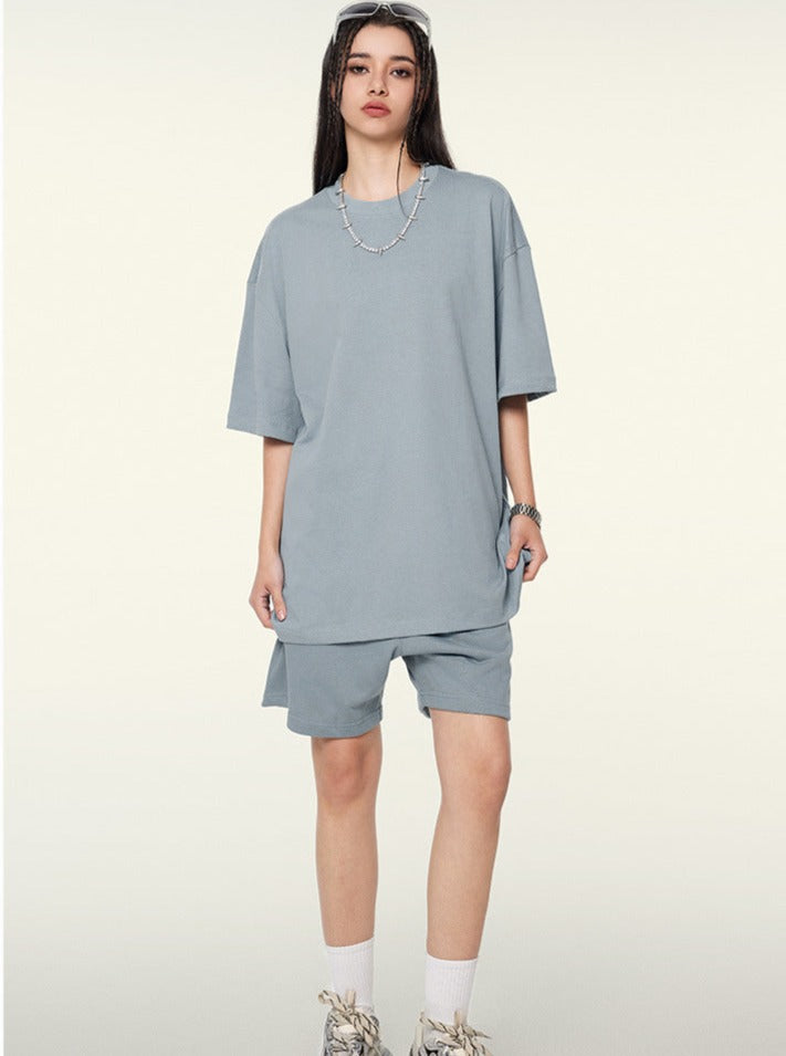 Frau in grauem Oversize-T-Shirt und Shorts, modisch, lässig, Streetwear, Sommeroutfit, trendige Kleidung, urbaner Stil, bequeme Passform.