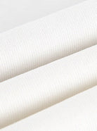 Weiße Baumwollstoffrolle, Nahaufnahme. Hochwertiger, weicher Textilstoff, ideal für Bekleidung und Heimtextilien. Nachhaltig und vielseitig.