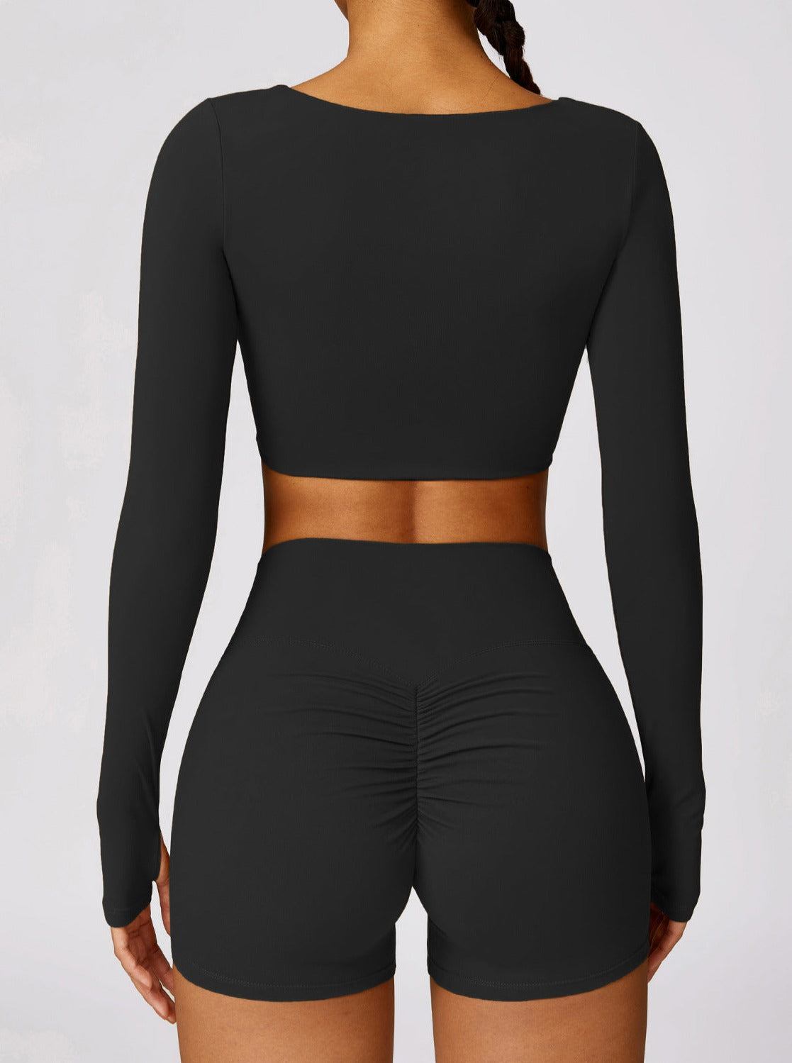 Damen-Sportset in Schwarz, bestehend aus langärmligem Crop-Top und Shorts. Ideal für Fitness, Yoga und Sportbekleidung. Bequem und stylisch.