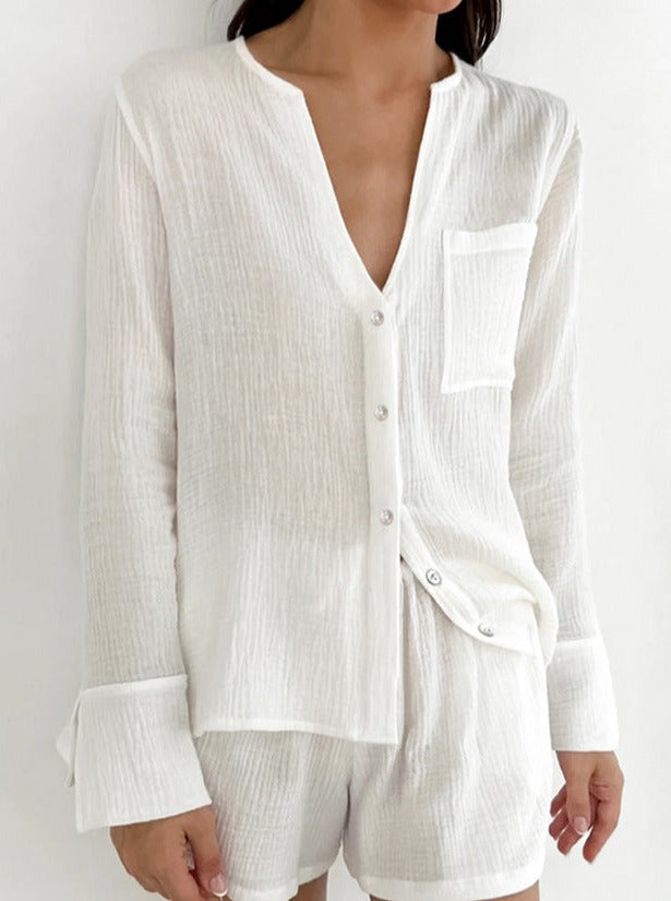 Damen Pyjama-Set aus weißem, leichtem Stoff mit Knopfleiste und Brusttasche. Ideal für bequeme Nachtwäsche und stilvolle Loungewear.
