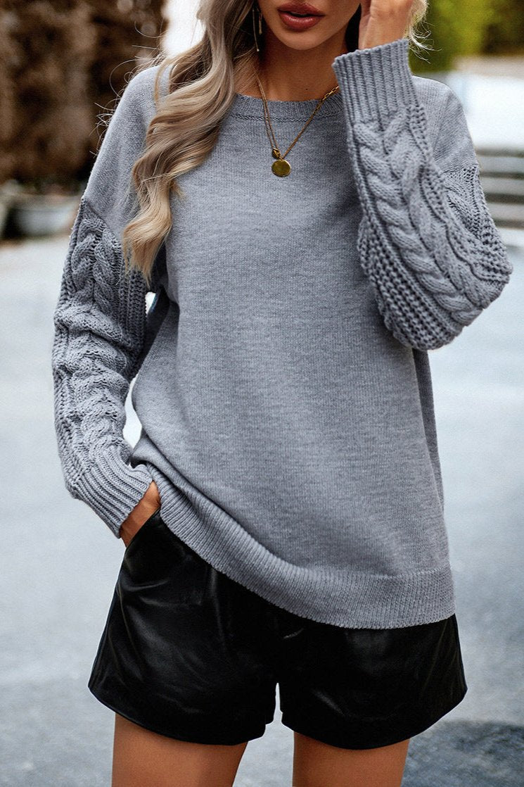 Grauer Strickpullover mit Zopfmuster, Damenmode, lässiger Herbstlook, weiches Material, stilvoller Langarm, ideal für kühle Tage.