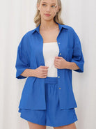 Frau in blauer Sommerbluse und Shorts, lässiger Look, Mode für Damen, Freizeitkleidung, trendige Outfits, bequeme Sommermode, stilvoll.