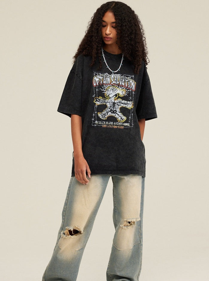 Frau in schwarzem Oversize-T-Shirt mit grafischem Print und zerrissenen Jeans. Modetrend, Streetwear, lässiger Look, urbaner Stil.