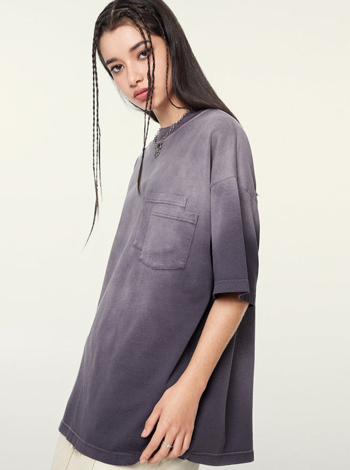 Graues Oversize-T-Shirt für Damen mit Brusttasche, lässiger Stil. Perfekt für Streetwear und Freizeitmode. Hochwertige Baumwolle, trendiges Design.