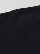 Schwarzes T-Shirt aus Baumwolle, Nahaufnahme der Naht. Hochwertige Verarbeitung, ideal für lässige Mode. Perfekt für Herren und Damen.