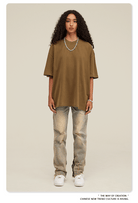 Frau in lässigem Outfit: braunes Oversize-T-Shirt, zerrissene Jeans, weiße Sneaker. Modetrend, Streetwear, urbaner Stil, Freizeitlook.