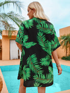 Frau im tropischen Kimono mit Palmenmuster, steht am Pool. Sommermode, Strandkleidung, tropisches Design, entspannte Urlaubsatmosphäre.