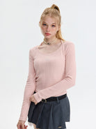 Damenmode: Eleganter, rosa Strickpullover mit Rundhalsausschnitt, kombiniert mit einem modischen, grauen Faltenrock. Perfekt für den Herbst.