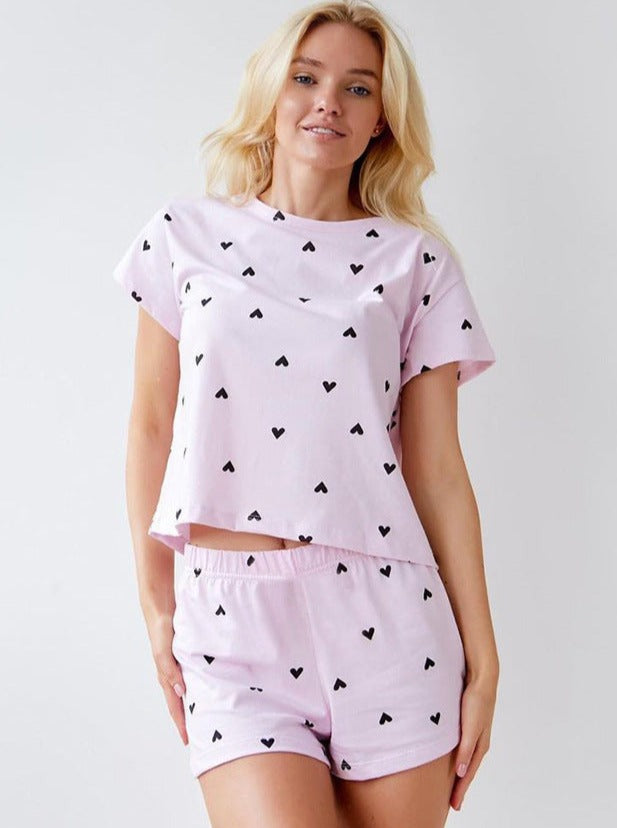 Damen-Pyjama-Set in Rosa mit schwarzen Herzmustern, bestehend aus T-Shirt und Shorts. Bequem, modisch, ideal für erholsamen Schlaf.