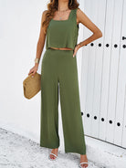 Damen Sommer-Outfit: Grünes ärmelloses Top und weite Hose, ideal für Freizeit und Strand. Perfekt kombiniert mit Strohtasche und Sandalen.