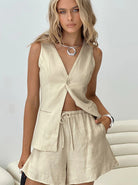 Beige Leinen-Set Damen: ärmellose Weste und Shorts, ideal für Sommermode. Stilvoll, leicht und atmungsaktiv, perfekt für warme Tage.