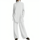 Elegantes Damen-Outfit: Weißer Oversize-Pullover mit Rollkragen und weite Hose. Perfekt für minimalistischen, stilvollen Look.