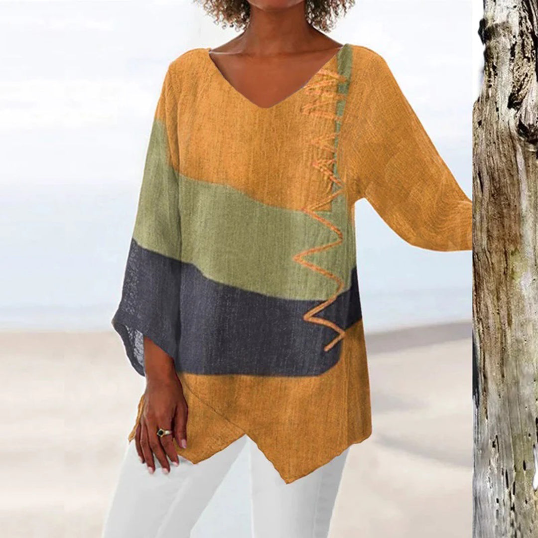 Frau in farbenfroher Tunika am Strand, orange-grün-schwarz, lässige Damenmode, Sommeroutfit.