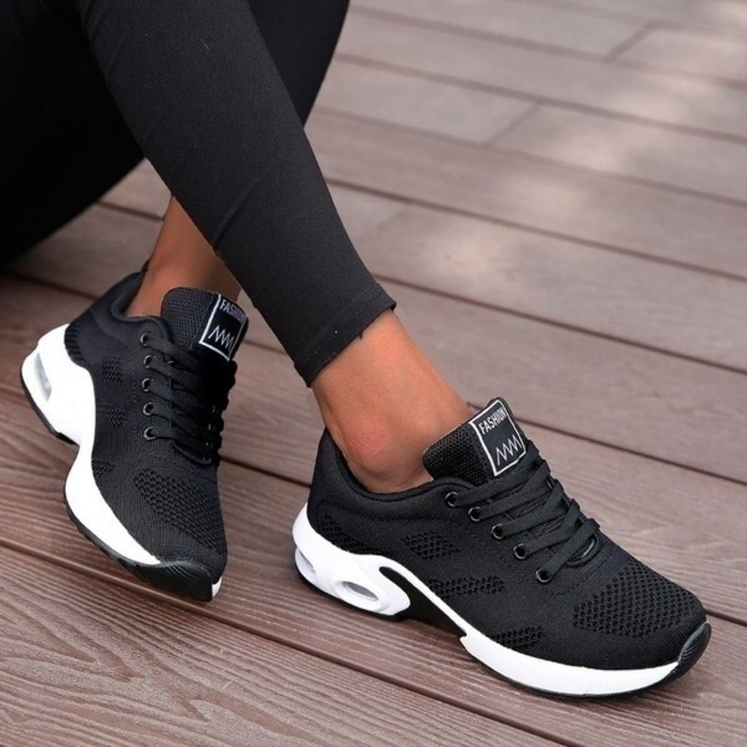 Schwarze Damen-Sneaker mit weißer Sohle, atmungsaktivem Mesh-Obermaterial, ideal für Sport und Freizeit. Trendige, bequeme Sportschuhe.