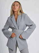 Grauer Damenblazer mit Gürtel, elegantes Design, ideal für Business- und Freizeitoutfits. Hochwertige Mode für stilbewusste Frauen.