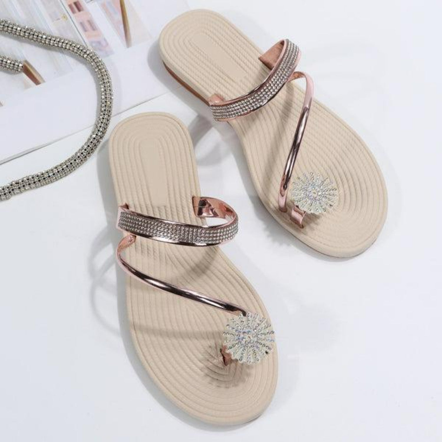 Elegante Damen-Sandalen mit Strassverzierung, flachem Design und beigem Fußbett. Perfekt für Sommermode und stilvolle Freizeitoutfits.