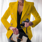 Eleganter gelber Blazer mit goldenen Knöpfen, kombiniert mit schwarzem Top und modischer Handtasche. Perfekt für stilvolle Business-Looks.
