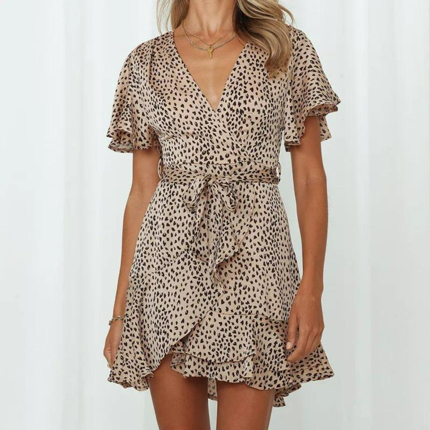 Leopardenkleid mit V-Ausschnitt und Rüschen, ideal für Sommermode. Elegantes Design, tailliert mit Gürtel, perfekt für trendige Outfits.