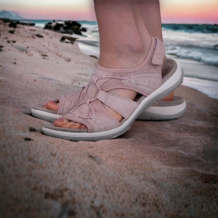 Damen-Sandalen in Rosa auf Sandstrand, ideal für Sommer und Strandurlaub. Bequeme, stilvolle Schuhe mit rutschfester Sohle. Perfekt für Outdoor-Abenteuer.