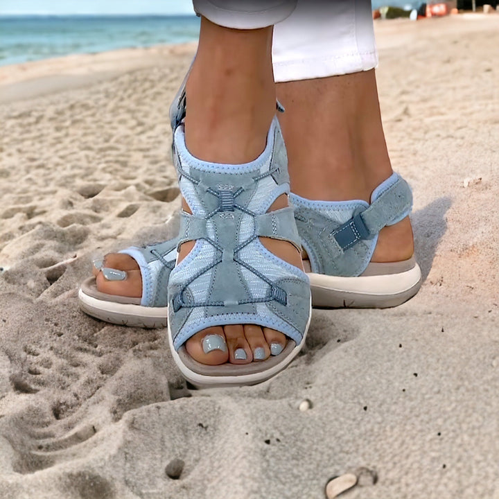 Damen-Sandalen in Hellblau am Strand, ideal für Sommermode. Bequeme, stilvolle Schuhe für Freizeit und Urlaub. Perfekt für Strandspaziergänge.