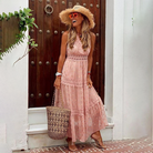 Frau in rosa Sommerkleid mit Strohhut und Korbtasche vor Holztür. Perfektes Outfit für Strandurlaub. Boho-Chic, Sommermode, Damenkleider.