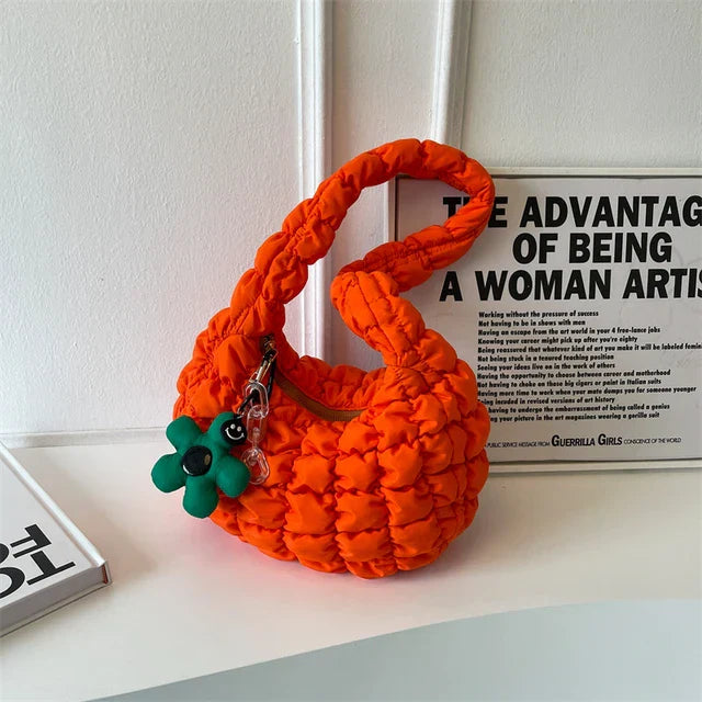 Leuchtend orange gesteppte Schultertasche für Damen, 2023, mit Rüschen, großer Kapazität und Blumenanhänger. Modische, trendige Handtasche.