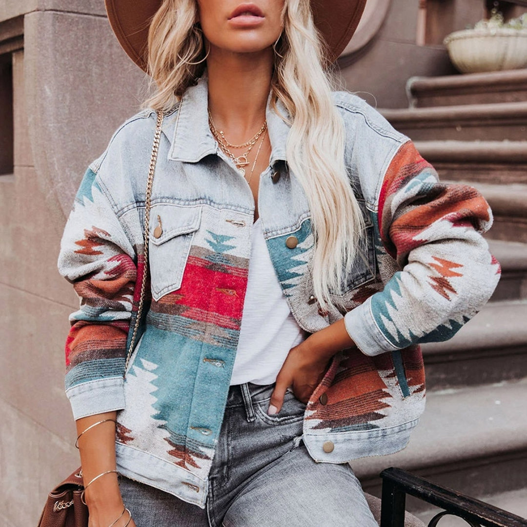 Frau in modischer Azteken-Jeansjacke, kombiniert mit weißem T-Shirt und grauer Jeans. Trendige Damenmode, Streetstyle, Herbstoutfit.