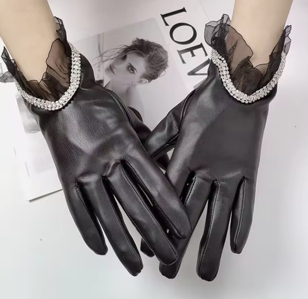 Elegante schwarze Lederhandschuhe mit Strassverzierung und Rüschen, ideal für stilvolle Mode und Accessoires. Perfekt für besondere Anlässe.