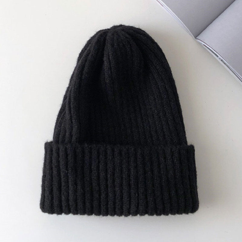 Schwarze Strickmütze aus Wolle, warm und stilvoll, ideal für Wintermode. Perfekt für Herren und Damen, vielseitig kombinierbar.
