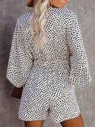 Damen-Overall mit schwarz-weißem Dalmatiner-Muster, lockeren Ärmeln und taillierter Passform. Modetrend, stilvoll, bequem, Sommermode.