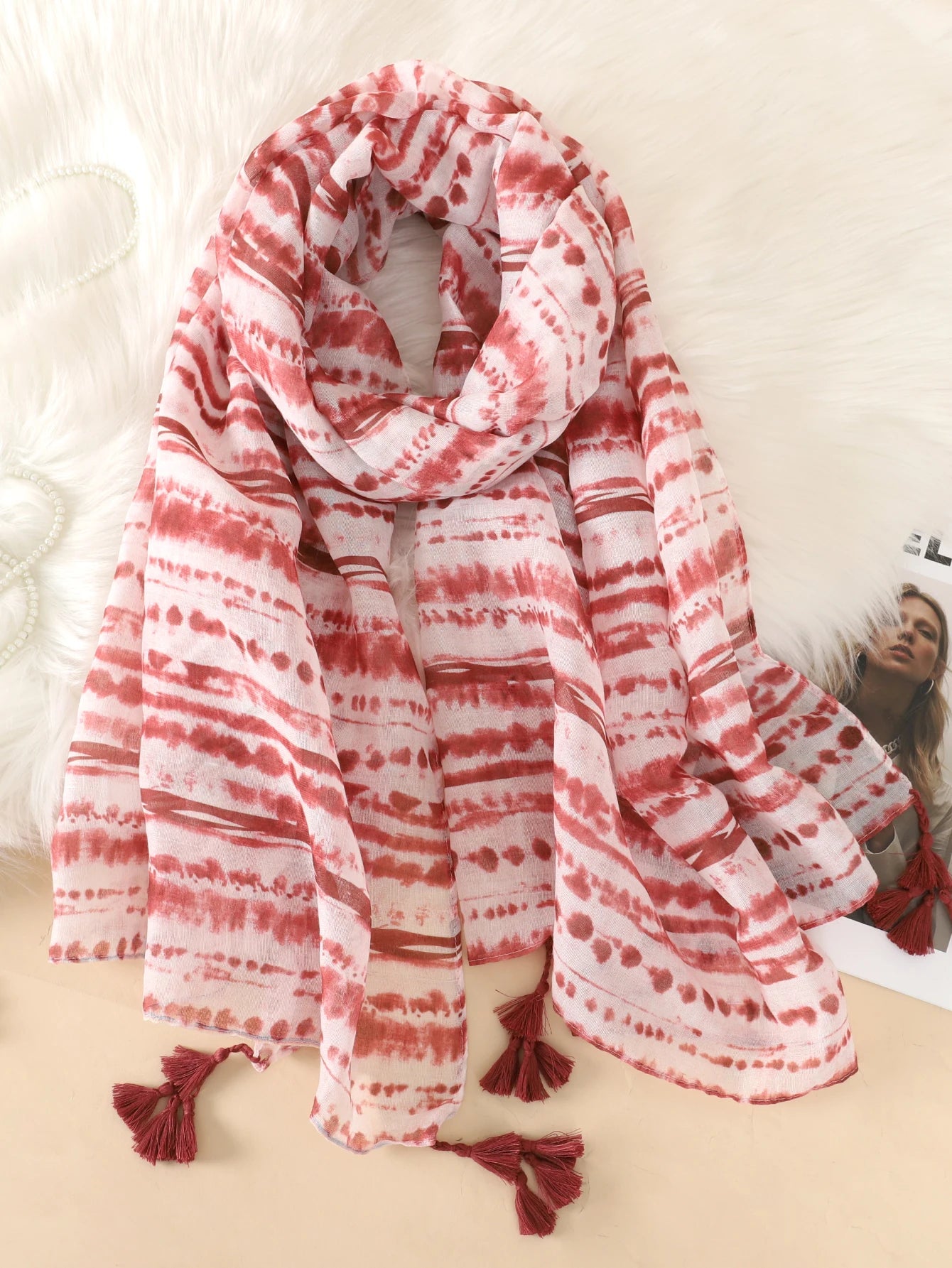 Roter und weißer gestreifter Schal mit Quasten, ideal für Damenmode. Perfekt als Accessoire für Herbst und Winter. Hochwertiger Stoff.