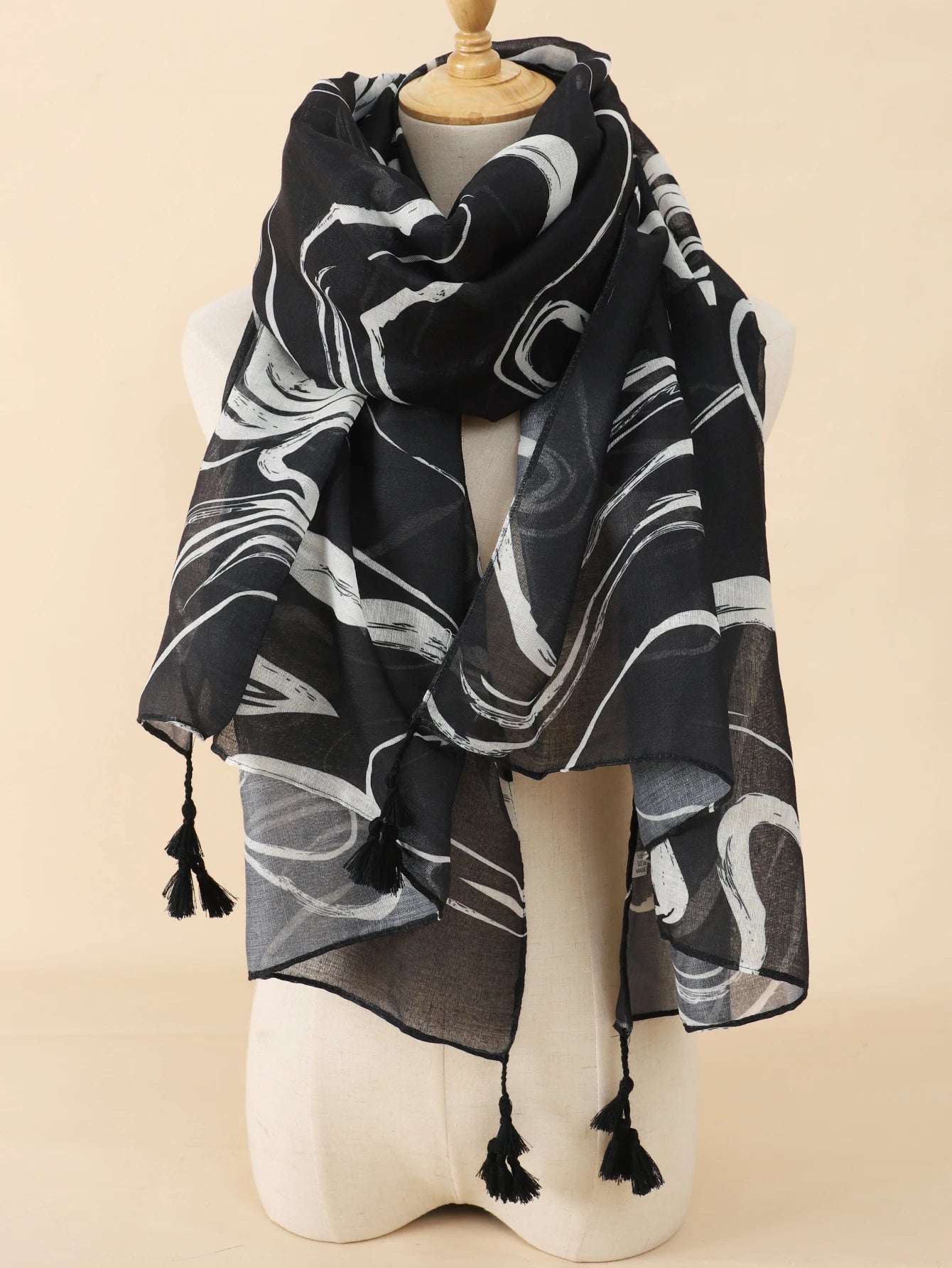 Schwarzer Schal mit weißem abstraktem Muster, leicht und elegant, ideal für Damenmode. Perfekt als Accessoire für Herbst und Winter.