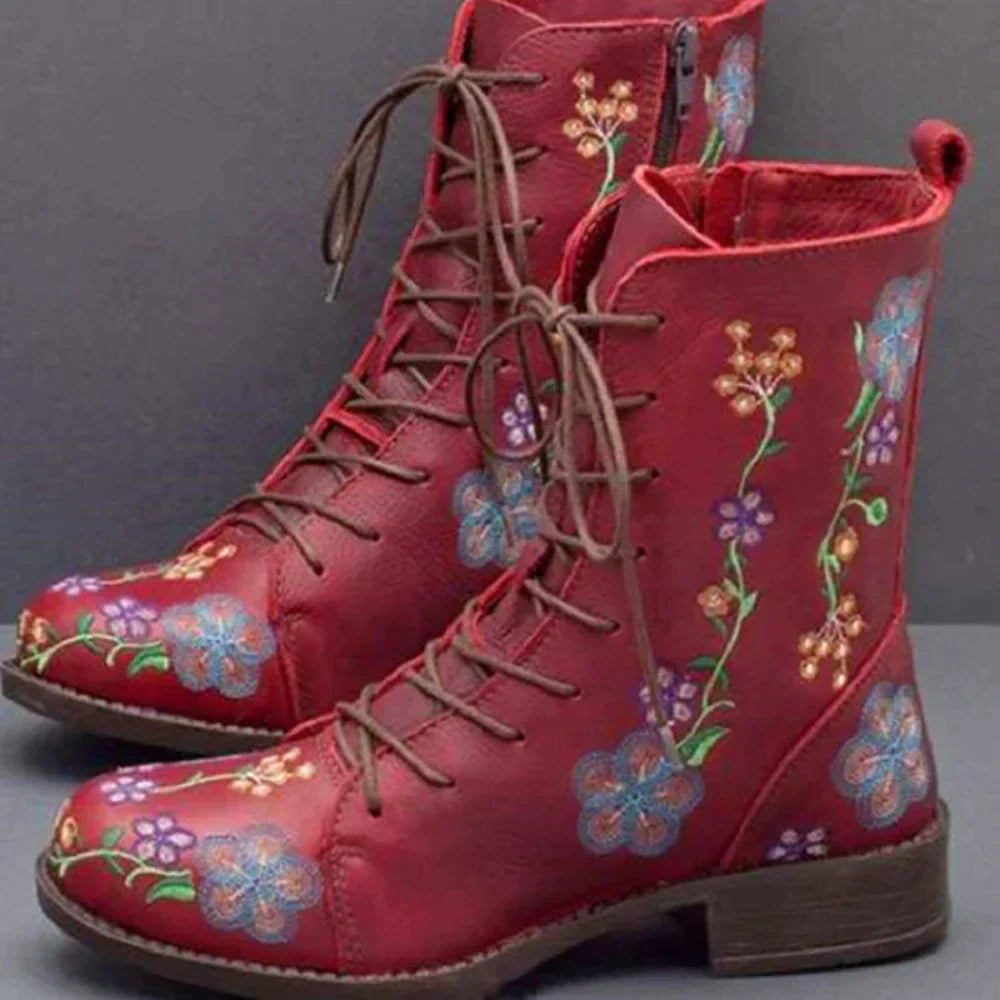 Rote Damenstiefel mit floralen Stickereien, Schnürung und Reißverschluss. Modische, bequeme Schuhe für Herbst und Winter. Vintage-Stil.