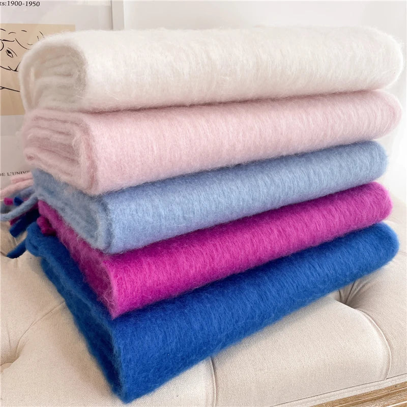 Weiche, flauschige Decken in Weiß, Rosa, Blau und Lila, gestapelt auf einem Sofa. Perfekt für gemütliche Wohnaccessoires und Heimdekoration.