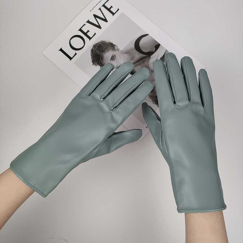 Elegante grüne Lederhandschuhe auf einem Magazin, stilvolles Accessoire, modisch, hochwertig, Damenhandschuhe, zeitloses Design, Luxusmode.
