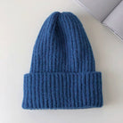 Blaue Strickmütze aus Wolle, warm und stilvoll, ideal für Wintermode. Perfekt für kalte Tage, modisches Accessoire für Damen und Herren.
