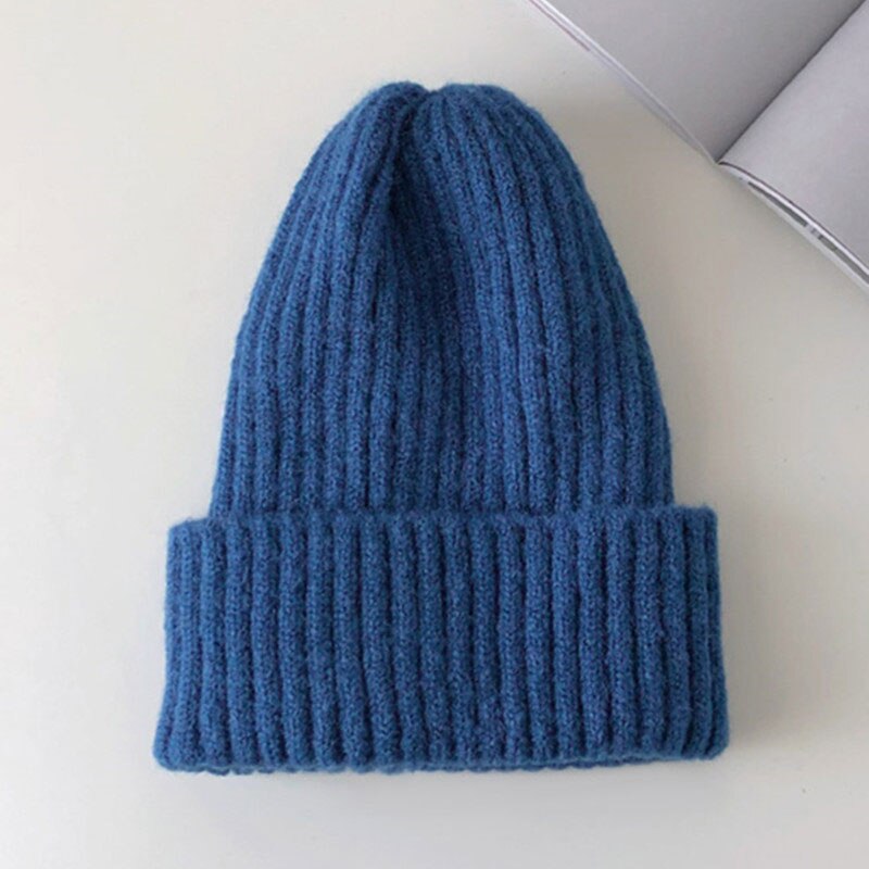 Blaue Strickmütze aus Wolle, warm und stilvoll, ideal für Wintermode. Perfekt für kalte Tage, modisches Accessoire für Damen und Herren.
