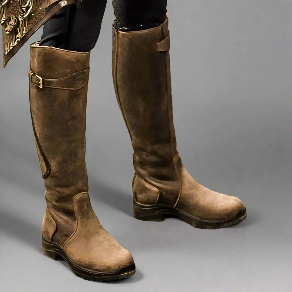 Braune Lederstiefel, kniehoch, mit Schnallen und robustem Design. Perfekt für Outdoor-Aktivitäten und modische Herbst-Looks.