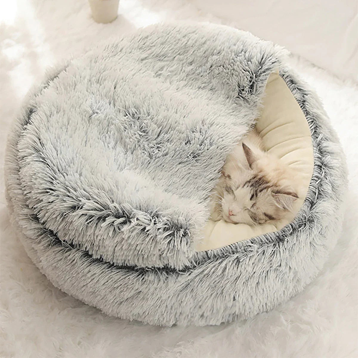 Katzenbett aus Plüsch, rund, grau, mit schlafender Katze, gemütlich, Haustierbedarf.