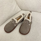 Beige Hausschuhe mit weichem Futter auf einem Sofa. Perfekt für Komfort und Wärme. Ideal für gemütliche Winterabende zu Hause.