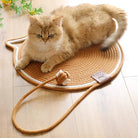 Katzenkratzmatte aus Sisal, rund, mit Spielzeug, beige, für Haustiere auf Holzboden.