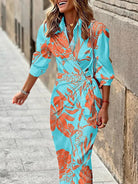 Frau in türkisfarbenem, geblümtem Kleid auf Straße. Modetrend, Sommerkleid, florales Design, Damenmode, stilvoll, elegant.