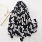 Schwarzer Schal mit weißen Schmetterlingsmotiven, weiches Material, modisches Accessoire, ideal für Frühling und Herbst, Damenmode.