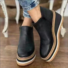 Schwarze Damen-Wedges aus Leder mit weißer Sohle, modisch und bequem, ideal für den Alltag. Perfekte Kombination aus Stil und Komfort.