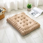 Beiges, quadratisches Bodenkissen aus Samt auf Holzboden, ideal für Wohnzimmer-Dekoration.